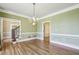 Dining room with hardwood flooring, decorative trim, and chandelier lighting fixture at 2975 Coles Way, Atlanta, GA 30350