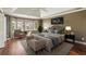 Comfortable main bedroom featuring a tray ceiling, large windows, and a cozy seating area with a chair at 2975 Coles Way, Atlanta, GA 30350