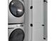 Stacked washer and dryer set next to a door, offering convenience and space-saving design at 3920 Cash Lndg, Marietta, GA 30066