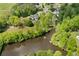 Aerial view of a home with a pool on a lake surrounded by lush trees, a dock, and other homes nearby at 109 Hawks Bnd, Canton, GA 30115