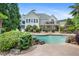 Tranquil backyard with a sparkling pool, mature landscaping, a deck, and a stone retaining wall at 109 Hawks Bnd, Canton, GA 30115
