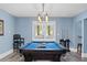 Pool table with blue felt surrounded by seating and French doors leading to outside at 109 Hawks Bnd, Canton, GA 30115