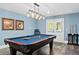 Well-lit basement pool table with hardwood floors surrounded by seating and French doors at 109 Hawks Bnd, Canton, GA 30115