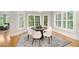 Sunlit dining area with large windows, hardwood floors, stylish rug and seating for four at 109 Hawks Bnd, Canton, GA 30115