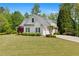 Charming two-story home with well-manicured lawn, garden beds, and a circular driveway leading to a two-car garage at 109 Hawks Bnd, Canton, GA 30115