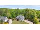 Aerial view of a two-story home with a lush lawn, driveway, and detached two-car garage, surrounded by mature trees at 109 Hawks Bnd, Canton, GA 30115