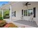 Charming front porch with rocking chairs and a hanging chair, enhanced by black shutters and flower garden at 109 Hawks Bnd, Canton, GA 30115