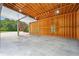 Bright garage interior featuring exposed wood framing, concrete floor, with windows offering a view of the yard at 109 Hawks Bnd, Canton, GA 30115