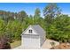 Two-car detached garage with white siding, a gable roof, and mature landscaping, set amongst mature trees at 109 Hawks Bnd, Canton, GA 30115