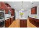 Modern kitchen features an island with marble countertops, cherry cabinets, and stainless steel appliances at 109 Hawks Bnd, Canton, GA 30115