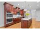 Gourmet kitchen with double ovens, stainless steel appliances, and a central island with cherry cabinets at 109 Hawks Bnd, Canton, GA 30115