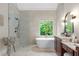Bright bathroom featuring free standing tub, oversized shower, and double vanity at 109 Hawks Bnd, Canton, GA 30115