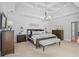 Spacious main bedroom features a decorative wood accent wall, tray ceilings, and a charming chandelier at 109 Hawks Bnd, Canton, GA 30115