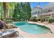 Beautiful backyard pool oasis with stone waterfall feature, lush landscaping, and a relaxing covered lounge area at 109 Hawks Bnd, Canton, GA 30115