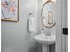 A neutral-toned powder room has a pedestal sink, a gold framed mirror, and artwork at 109 Hawks Bnd, Canton, GA 30115