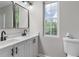 Bathroom featuring double sinks, quartz countertops, black hardware and a window at 1758 Bridgestone Ct, Marietta, GA 30066