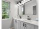Bathroom featuring double sinks, quartz countertops, black hardware and a window at 1758 Bridgestone Ct, Marietta, GA 30066