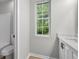 Bathroom featuring a window, a single sink vanity, toilet and tub at 1758 Bridgestone Ct, Marietta, GA 30066