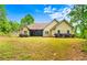 Large backyard with lush greenery and a home exterior featuring a charming screened-in porch at 2400 Honey Ct, Mcdonough, GA 30252