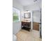 Bathroom with tile floor, dark wood vanity, and window with natural light at 2400 Honey Ct, Mcdonough, GA 30252