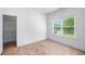 Bright bedroom featuring a window with blinds and a spacious closet providing ample storage at 2400 Honey Ct, Mcdonough, GA 30252