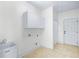 Utility room with storage cabinets, sink, tile floors, and a door leading to the exterior at 2400 Honey Ct, Mcdonough, GA 30252