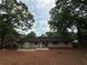 Spacious backyard featuring a one-story, painted brick home and large trees overhead at 2401 Winshire Drive, Decatur, GA 30035