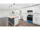 Open concept kitchen features stainless appliances, white cabinets, an island with wood countertop, and trendy backsplash at 2401 Winshire Drive, Decatur, GA 30035