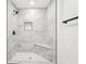 Walk-in shower showcases gray tiling, a built-in niche, a shower bench, and black fixtures at 2401 Winshire Drive, Decatur, GA 30035