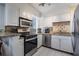 Well-lit kitchen with stainless steel appliances, granite countertops and white cabinetry at 2479 Peachtree Ne St # 1414, Atlanta, GA 30305
