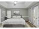 A well lit bedroom featuring hardwood floors, tray ceilings, and a large bed, plus private patio access at 405 Settlers Ridge Ln, Hiram, GA 30141