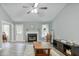 Bright living room featuring a cozy fireplace, ceiling fan, and wood-look flooring at 405 Settlers Ridge Ln, Hiram, GA 30141