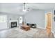 Bright living room featuring a cozy fireplace, ceiling fan, and wood-look flooring at 405 Settlers Ridge Ln, Hiram, GA 30141