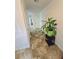 Hallway featuring neutral tile flooring, white walls, and a decorative potted plant on a black table at 2365 Hackamore Dr, Atlanta, GA 30349