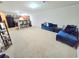 Spacious carpeted living room open to the kitchen with a comfortable blue sofa and ample natural light at 2365 Hackamore Dr, Atlanta, GA 30349