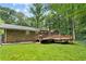 Brick home featuring a spacious backyard with a large wooden deck and a fenced perimeter at 4293 Smithsonia Dr, Tucker, GA 30084