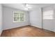 Neutral bedroom with hardwood flooring, ceiling fan, and natural light from two windows at 4293 Smithsonia Dr, Tucker, GA 30084
