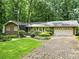 Charming single-story home featuring a manicured lawn, brick accents, and a two-car garage at 4293 Smithsonia Dr, Tucker, GA 30084
