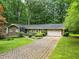 Charming single-story home featuring a manicured lawn, brick accents, and a two-car garage at 4293 Smithsonia Dr, Tucker, GA 30084