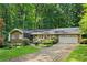 Charming ranch home with brick accents, lush landscaping, and a brick driveway, surrounded by mature trees at 4293 Smithsonia Dr, Tucker, GA 30084