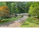 Beautiful front yard with mature trees, a brick driveway, and manicured landscaping surrounding this ranch style home at 4293 Smithsonia Dr, Tucker, GA 30084