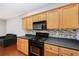 Bright kitchen features wooden cabinets, dark counters, and stainless steel appliances at 786 Brookside Parc Ln, Avondale Estates, GA 30002