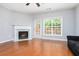 Cozy living room with hardwood flooring, large windows, and a classic fireplace at 786 Brookside Parc Ln, Avondale Estates, GA 30002