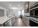 Modern kitchen featuring stainless steel appliances, quartz countertops, and a dining area at 9913 Stretford Rd, Douglasville, GA 30135