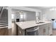 Modern kitchen island with a stainless steel dishwasher overlooking the living room fireplace at 9913 Stretford Rd, Douglasville, GA 30135