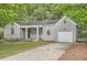 Charming one-story home with brick facade, covered porch, attached garage and mature trees at 1723 Ritcherson Se St, Marietta, GA 30060