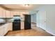 Bright kitchen featuring wood-look flooring, white cabinets, and black appliances at 1723 Ritcherson Se St, Marietta, GA 30060
