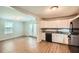 Bright kitchen boasts white cabinets, granite countertops, and stainless steel appliances next to a dining area at 1723 Ritcherson Se St, Marietta, GA 30060
