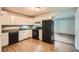 Well-lit kitchen featuring wood-look flooring, white cabinets, and black appliances at 1723 Ritcherson Se St, Marietta, GA 30060