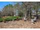 Landscaped backyard with seating area, shade trees and manicured bushes at 233 Millstone Pkwy, Woodstock, GA 30188
